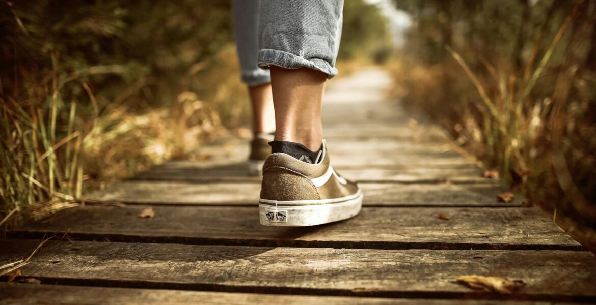 person stands on brown pathway