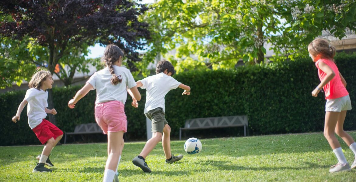 young kids playing football on the field